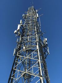 Low angle view of communications tower against clear blue sky