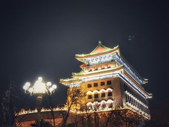 Low angle view of illuminated building against sky at night