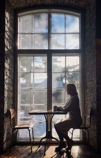 Woman looking through window