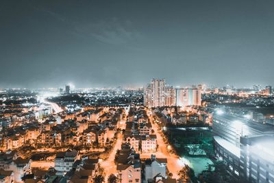 High angle view of illuminated city buildings against sky