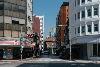 Street amidst buildings in city against clear sky