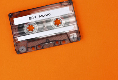 Close-up of cassette tape against orange background