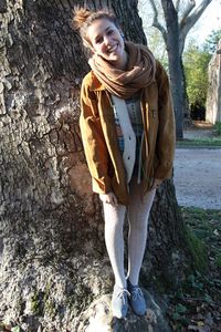 Portrait of man standing on tree trunk