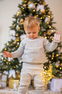 Portrait of cute girl playing with christmas tree