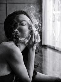 Portrait of young woman smoking cigarette