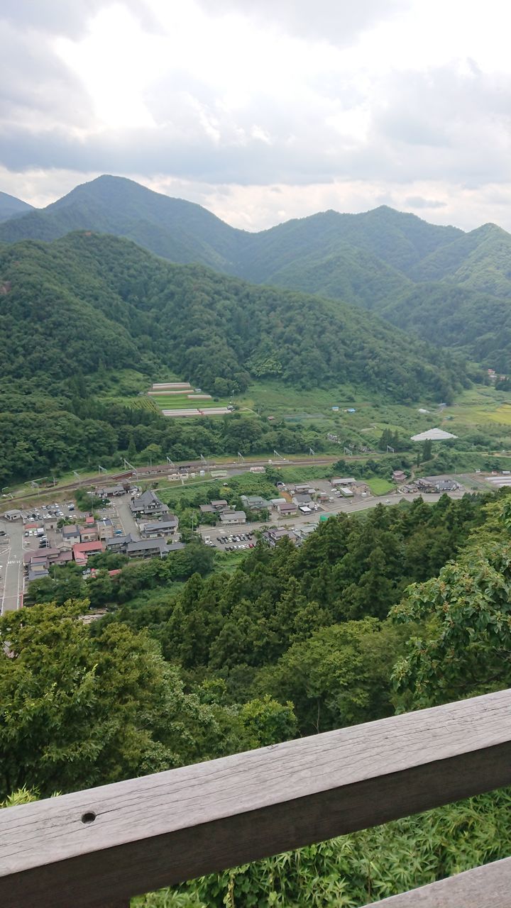 HIGH ANGLE VIEW OF GREEN LANDSCAPE AND MOUNTAINS AGAINST SKY