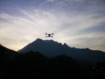 Low angle view of silhouette airplane flying against sky