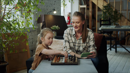 Mother playing chess with daughter