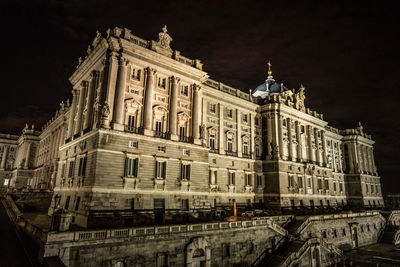 Low angle view of illuminated building against sky at night