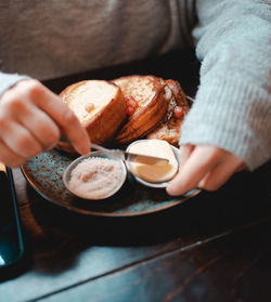 Midsection of woman spreading butter