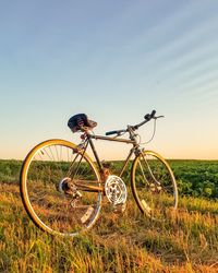Bicycle parked on field against clear sky