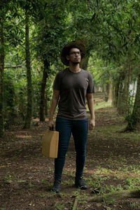 Portrait of young man standing in forest