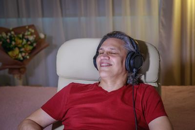 Smiling man listening music at home