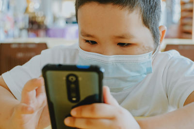 Close-up portrait of boy using mobile phone