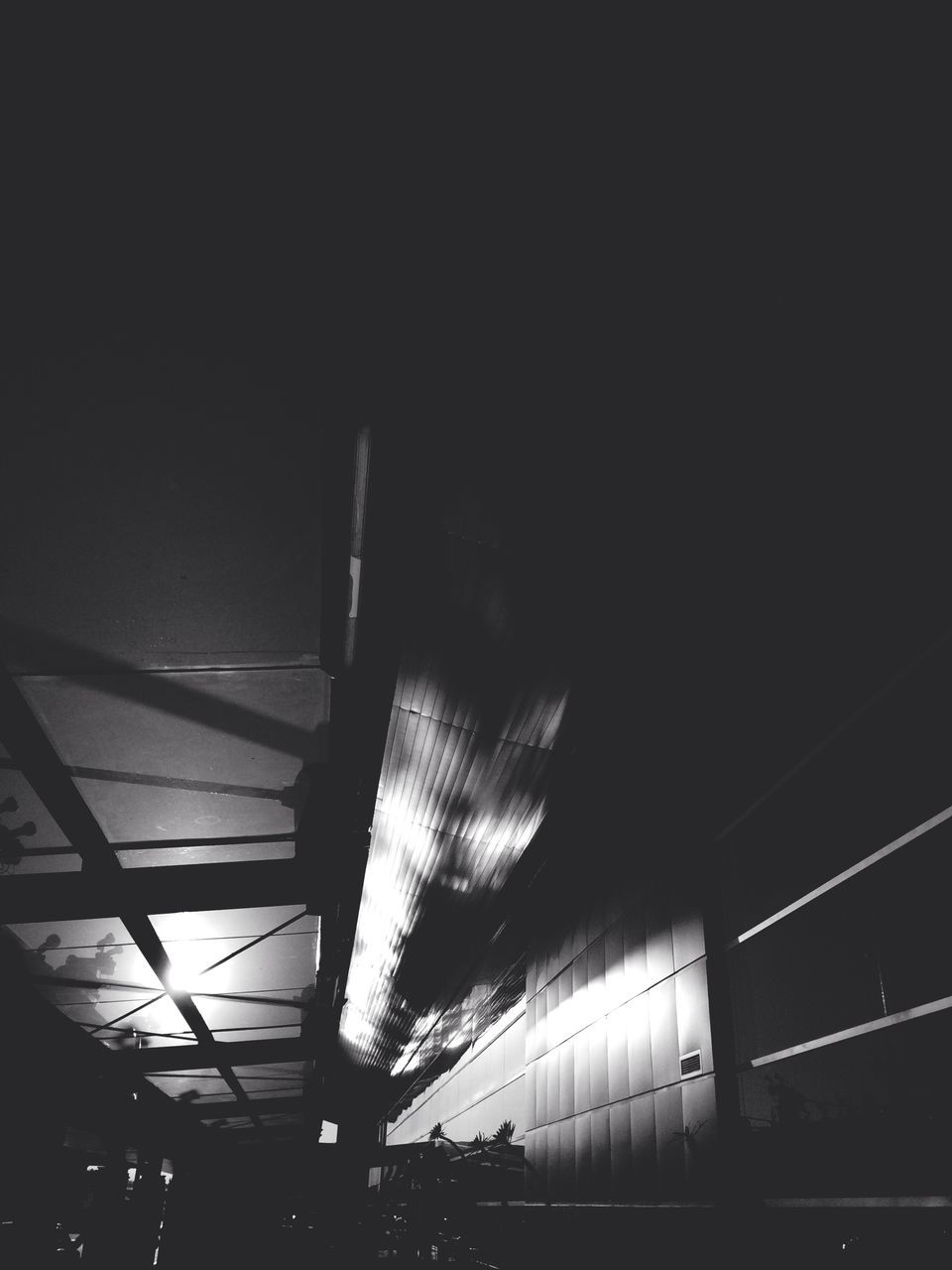 low angle view, illuminated, night, built structure, architecture, dark, lighting equipment, ceiling, indoors, connection, silhouette, copy space, clear sky, sky, no people, building, modern, electricity, light - natural phenomenon