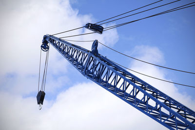 Low angle view of crane with pulley against sky