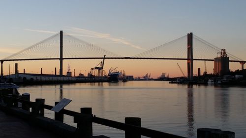 View of suspension bridge over river against sky