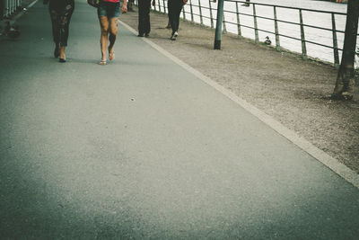 Low section of people walking on footpath in city