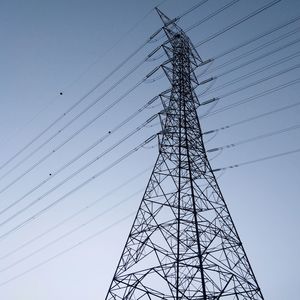 Low angle view of electricity pylon against clear sky