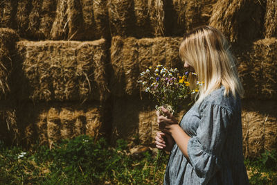 Side view of woman holding plants