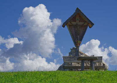 Low angle view of cross on field against sky