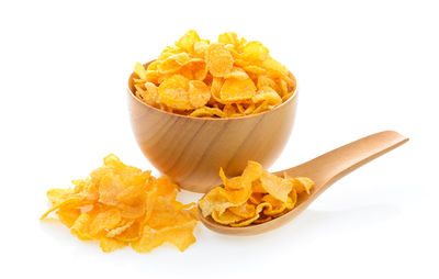 Close-up of orange slices in bowl against white background