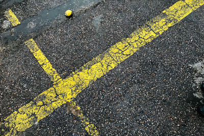 High angle view of yellow arrow symbol on road
