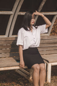 Full length of woman sitting on bench