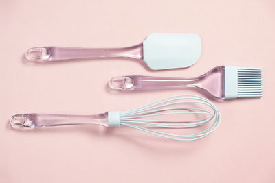 Directly above shot of kitchen utensils on pink background