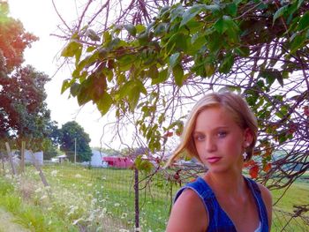 Portrait of young woman against trees