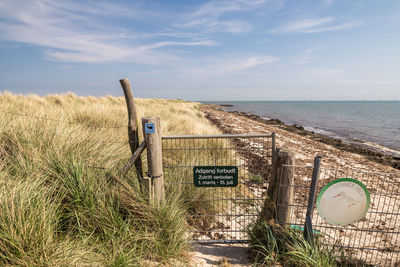 Wooden posts on beach against sky