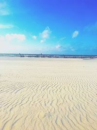 Scenic view of beach against blue sky