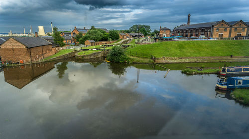 Reflection of houses in lake against sky