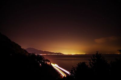 Scenic view of lake against mountains at night