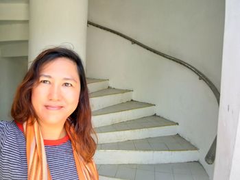 Portrait of smiling woman on staircase