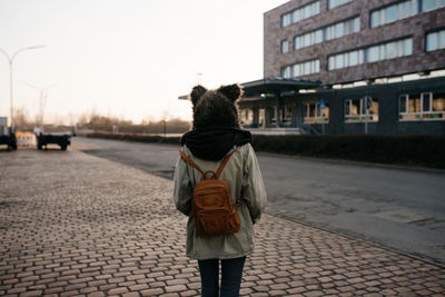 Rear view of woman walking on street in city