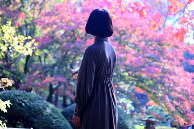 Rear view of woman standing against plants