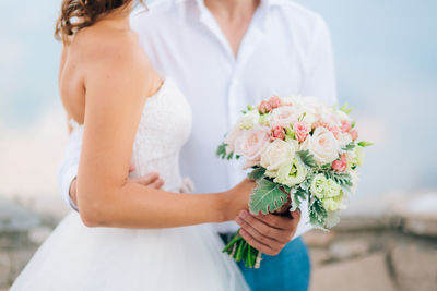 Midsection of woman holding flower bouquet
