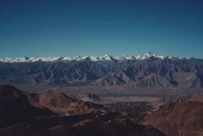 Scenic view of snowcapped mountains against clear blue sky