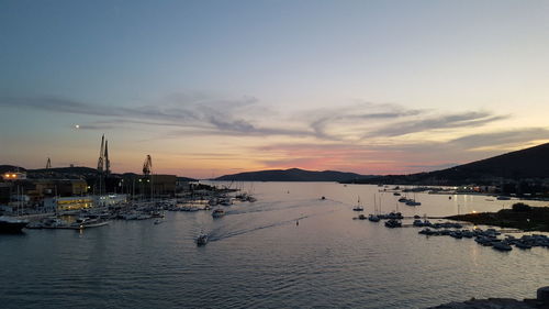 Boats in sea at sunset