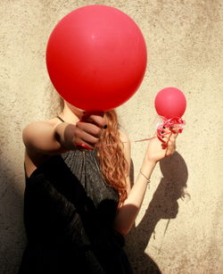 Rear view of girl holding balloons