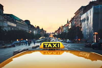 Close-up of taxi in city against sky