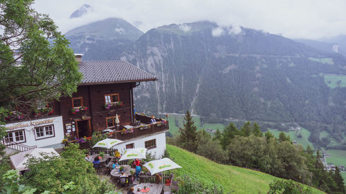 Houses by trees and mountains against sky
