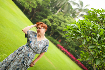 Young woman with green leaves in park