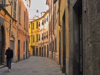 People walking in alley amidst buildings