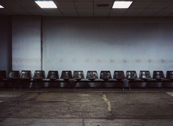 Empty seats on table against wall