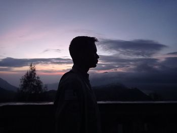 Silhouette man standing against sky during sunset