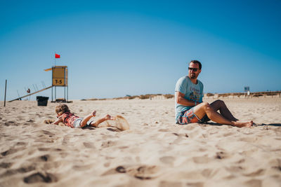 Father and child playing a the beach on a sunny day