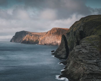 Rock formations by sea against sky