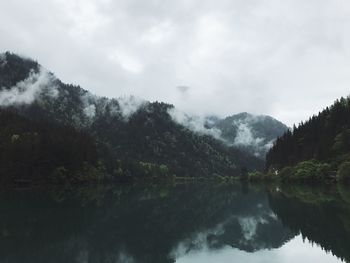 Scenic view of lake by trees against sky